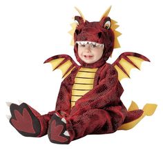 a baby in a dragon costume sitting on the ground