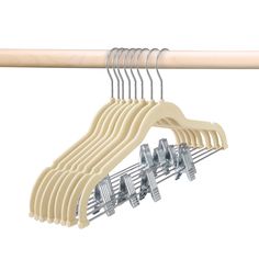 the wooden hangers are holding several pairs of clothes