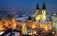 an aerial view of the old town square in prague at night with christmas trees and lit - up buildings