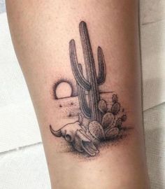 a small cactus tattoo on the leg with a longhorn in it's hand