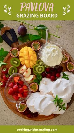 a wooden plate topped with fruit and whipped cream next to sliced kiwis, strawberries