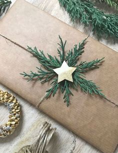 a present wrapped in brown paper with a gold star on top and green pine needles