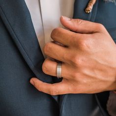 a man in a suit with two wedding bands on his lapel and wearing a ring