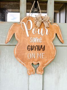 a wooden sign that says pour some gravy on me hanging from the side of a door