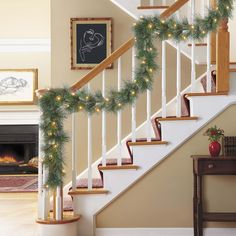 christmas garland on the banisters and stairs in front of an open fire place