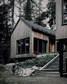 a bicycle is parked in front of a house with stairs leading to the upper level