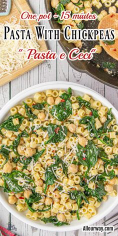 pasta with chickpeas and spinach in a white bowl on top of a wooden table