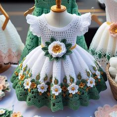 crocheted dresses are displayed on a table