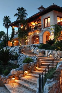 a house that is lit up at night with lights on the steps leading to it