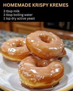 three glazed doughnuts on a plate sitting on a counter top with instructions for how to make krispy kremes