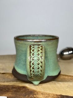 a green cup sitting on top of a wooden table