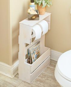 a white toilet sitting in a bathroom next to a wooden shelf with magazines on it