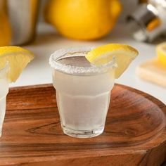 two lemon margaritas on a wooden platter