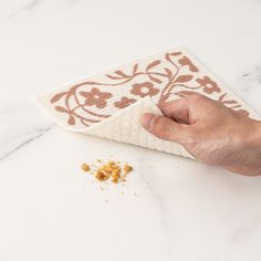 a hand holding a napkin over a table with food on it