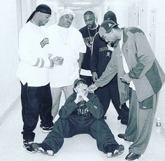 a group of men standing and sitting around each other in an office hallway with one man covering his mouth