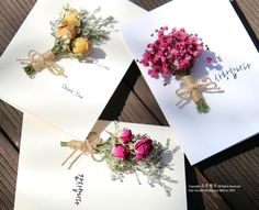 three greeting cards with flowers tied to them