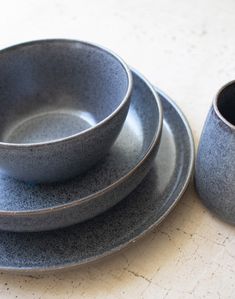 a set of four gray dishes sitting on top of a table