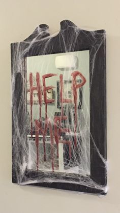 there is a sign with the words help in red on it and spider web around it