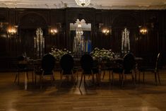 an elegant dining room with chandelier and wooden paneled walls in the background