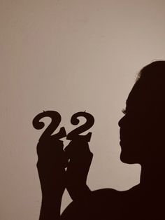 the silhouette of a woman holding a pair of scissors in front of her face with the number twenty on it