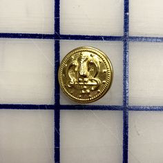 a gold coin sitting on top of a tiled wall