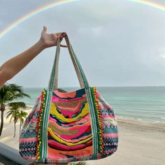 This bright and colorful tote bag is embellished with beading, sequins and pom poms and features a bright, vibrant print in teal, yellow and pink (among many other colors.) These fun and cute tote bags are the perfect size for the beach, an overnight trip or even just to run around town carrying the millions of everyday "necessities." With pops of teal, hot pink and yellow, interspersed with mini pom poms and sequins, this hand embellished tote bag is definitely a statement bag. Handcrafted by a Golden Sparkle, Animal Print Jumpsuit, Artisan Bag, Colorful Tote Bags, Leopard Bag, Embellished Bags, Teal Yellow, Shades Of Teal, Shades Of Turquoise