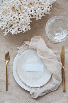 a place setting with white plates and silverware