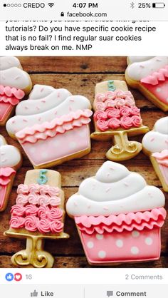 decorated cookies with pink and white frosting on wooden table