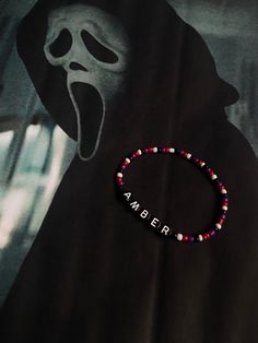 a beaded bracelet with the word amber written on it and a ghost behind it