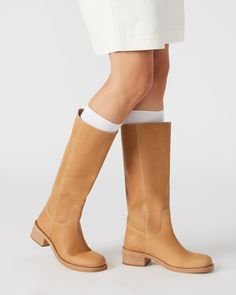 Effortlessly elevate your style with the RIGGS boot. With its square-toe and sleek design, this just-under-the-knee boot is a must-have for any fashion-conscious individual. This timeless boot provides both comfort and sophistication, making it the perfect addition to any outfit. 1.75 inch heel height 14.5 inch shaft circumference 13.25 inch shaft height Leather upper material Synthetic lining Synthetic sock Synthetic sole Imported Under The Knee Boots, Timeless Boots, Girls Tennis Shoes, Knee Boot, Boots Outfit, Fall Winter Outfits, Elevate Your Style, Tennis Shoes, Women's Boots