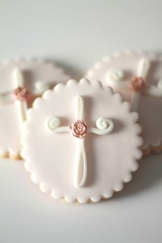 three cookies decorated with white and pink icing