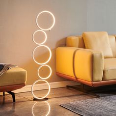 a living room with a couch, chair and floor lamp in the shape of circles