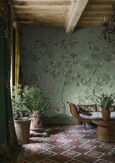 a living room with green walls and potted plants