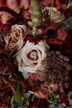 a bunch of flowers that are in some kind of vase on a table with red and pink colors