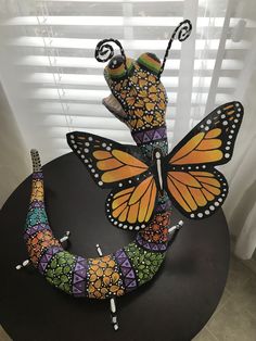 a colorful butterfly sculpture sitting on top of a table