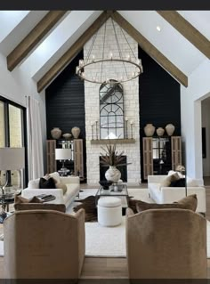 a living room with couches, chairs and a chandelier in the center