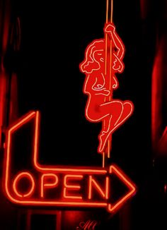 a neon sign that says open with a woman on it