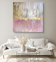 a living room with white furniture and a large painting on the wall above it's coffee table