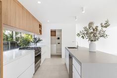 a modern kitchen with white cabinets and counter tops