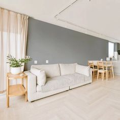 a living room filled with furniture next to a kitchen and dining room table on top of a hard wood floor