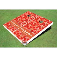 a red and white cornhole game set on green grass