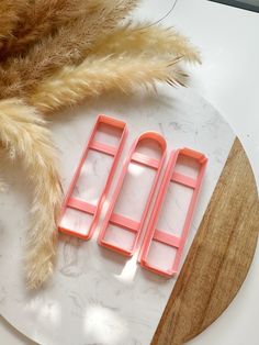 three pieces of pink plastic sitting on top of a white plate next to a brown fur