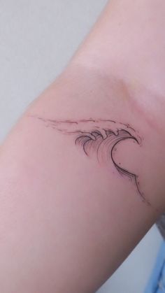 a woman's arm with a wave tattoo on it