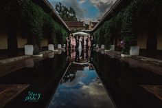 a group of women standing next to each other in front of a pool with water