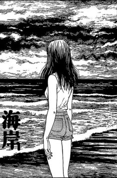 a woman standing on top of a beach next to the ocean in black and white