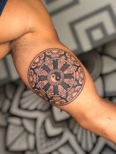 a man's arm with a tattoo on it that has a ying - o in the center