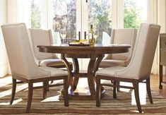 a dining room table with chairs and a wine bottle on the top of it in front of a window