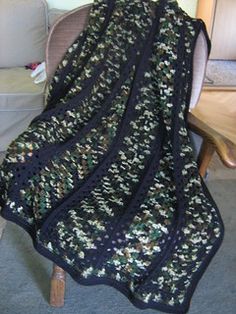 a black crocheted blanket sitting on top of a chair next to a couch