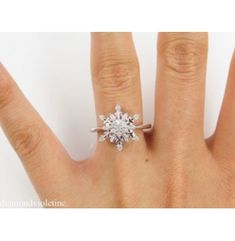 a woman's hand with a diamond ring on top of her finger, showing the center stone