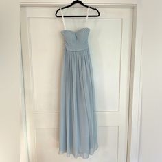 a light blue dress hanging on a white door